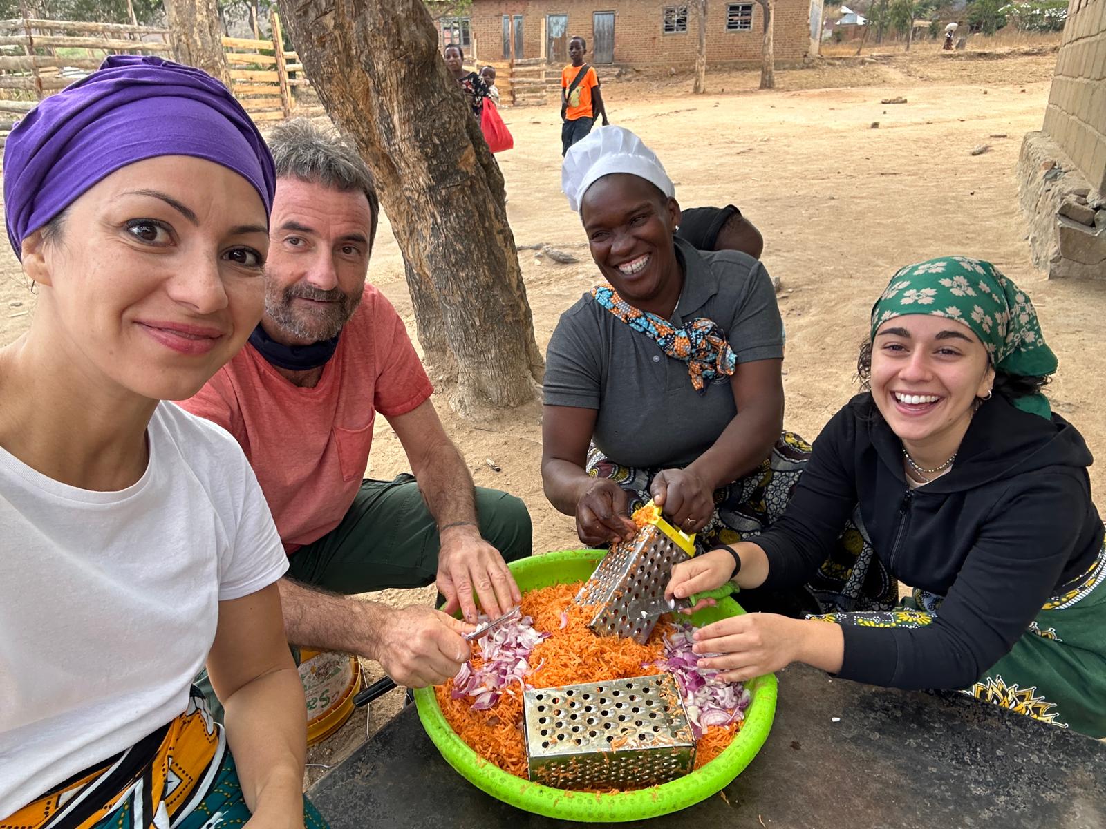 Massimo e due volontaria mentre preparano il cibo nelle mense scolastiche de L'Africa Chiama